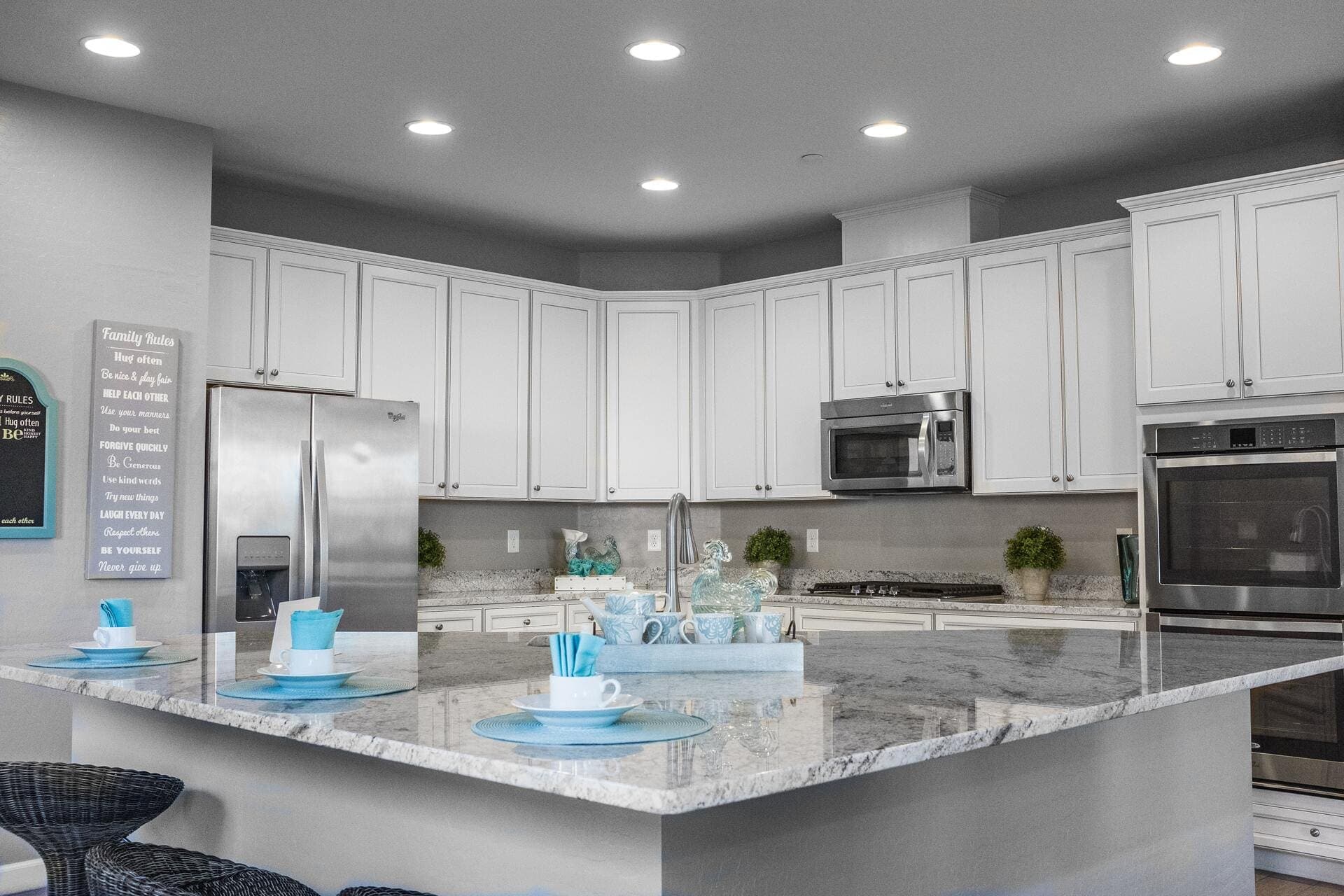Clean gray granite island in a bright white kitchen